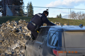 A BC Highway Patrol officer climbing out the window of a police SUV.